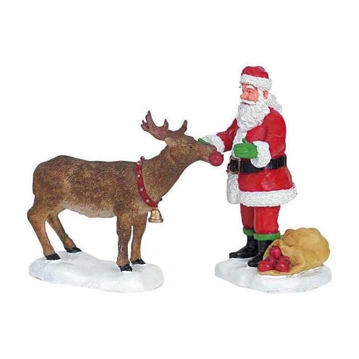 Scena Babbo Natale che offre dolci alle renne per villaggio natalizio
